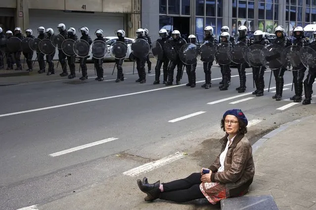 A woman sits in front of a police security line as people gather near EU headquarters during a so called “European Demonstration for Freedom and Democracy” protest against COVID-19 security measures taken by European governments, in Brussels, Saturday, May 29, 2021. (Photo by Olivier Matthys/AP Photo)