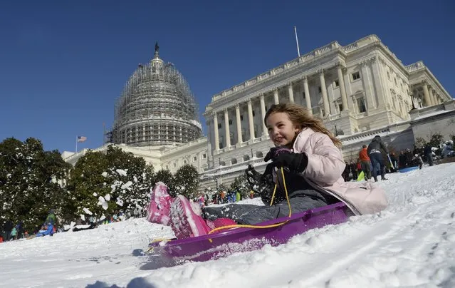 A young girl is sliding on the West Lawn of the US Capitol on January 24, 2016 in Washington. Millions of people in the eastern United States started digging out Sunday from a huge blizzard that brought New York and Washington to a standstill, but the travel woes were far from over. The storm – dubbed “Snowzilla” – killed at least 18 people after it walloped several states over 36 hours on Friday and Saturday, affecting an estimated 85 million residents who were told to stay off the roads and hunker down in doors for their own safety. (Photo by Olivier Douliery/AFP Photo)