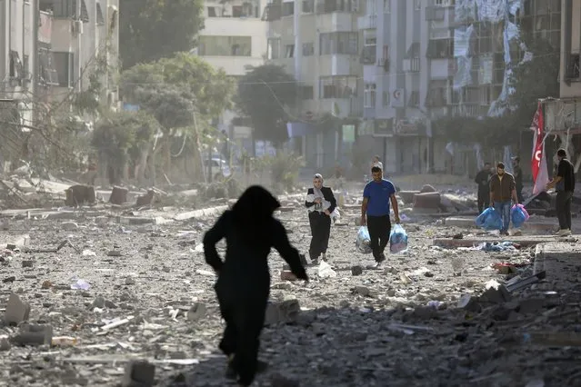 Palestinians leave their homes following Israeli bombardment on Gaza City, Monday, October 30, 2023. (Photo by Abed Khaled/AP Photo)