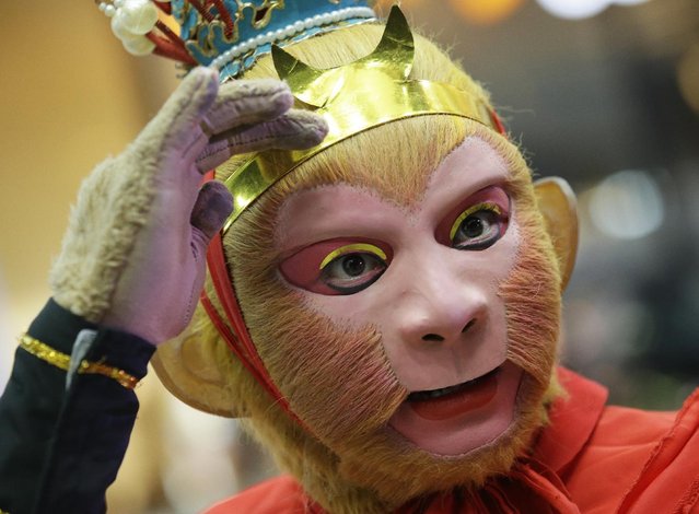 A Chinese man, dressed as the legendary Monkey God of Chinese folklore adjusts his mask and prepares before a show at Seacon Square in Bangkok, Thailand, Wednesday, February 3, 2016. The event was part of celebrations for the Chinese New Year which falls on Feb. 8 this year to mark the year of the monkey. (Photo by Sakchai Lalit/AP Photo)
