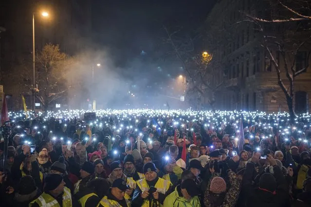 Anti-government demonstrators light up their mobile phones during their protest in the downtown of Budapest, Hungary, Sunday, December 16, 2018. (Photo by Zoltan Balogh/MTI via AP Photo)