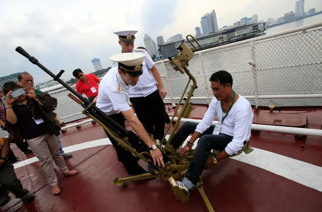 Members of the Russian Navy show to a visitor how to operate a 12.7mm anti-aircraft machine gun during a public tour onboard the Russian Navy vessel Admiral Tributs, a large anti-submarine vessel, docked at the South Harbor, Port Area, in Metro Manila, Philippines January 5, 2017. (Photo by Romeo Ranoco/Reuters)