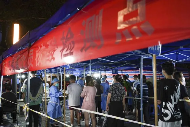 In this photo released by China's Xinhua News Agency, people line up for COVID-19 tests at a testing station in Nanjing in eastern China's Jiangsu Province, Wednesday, July 28, 2021. Roadblocks were set up to check drivers and a disease-control official called Thursday for increased testing of workers at Chinese ports after a rash of coronavirus cases traced to a major airport rattled authorities who thought they had the disease under control. (Photo by Li Bo/Xinhua via AP Photo)