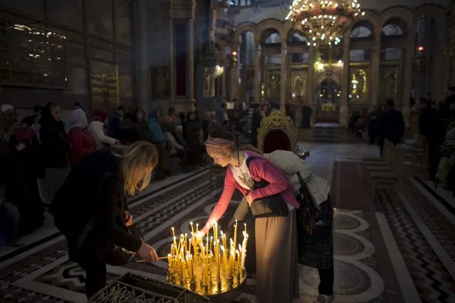 Christian worshippers light candles in the Church of the Holy Sepulchre in Jerusalem's Old City April 5, 2015. (Photo by Ronen Zvulun/Reuters)