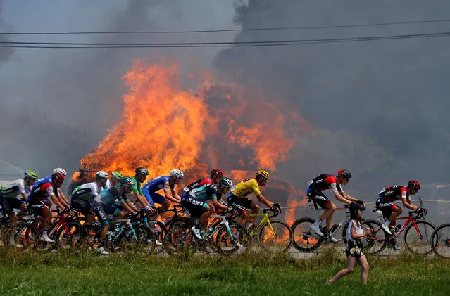 The peloton passes hay bales on fire during stage 6 of the Tour de France, July 12, 2018. (Photo by Stephane Mahe/Reuters)