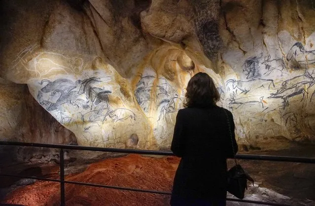 A visitor looks at a replica of pre-historic animals drawings on a wall during a press visit at the site of the Cavern of Pont-d'Arc project in Vallon Pont d'Arc April 8, 2015. (Photo by Robert Pratta/Reuters)
