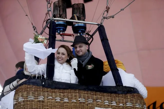 Newlyweds wave from a hot air balloons during the “Love Cup 2016” festival on Valentine's Day in Jekabpils, Latvia, February 14, 2016. (Photo by Ints Kalnins/Reuters)
