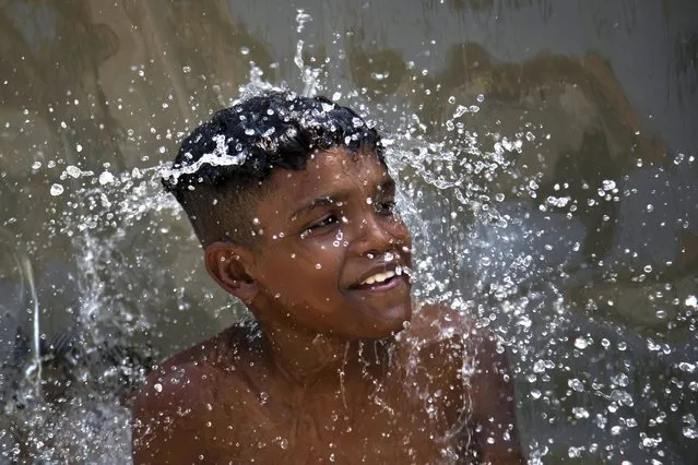 A youth cools off in a water fountain at Madureira Park amid a heat wave in Rio de Janeiro, Brazil, Wednesday, November 15, 2023. (Photo by Bruna Prado/AP Photo)
