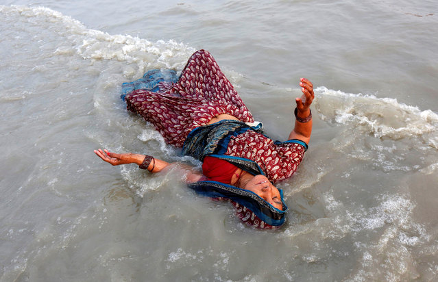 A Hindu pilgrim takes a dip in the Ganges river ahead of the one-day festival of Makar Sankranti, at Sagar Island, south of Kolkata, India January 13, 2017. (Photo by Rupak De Chowdhuri/Reuters)