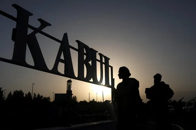 Taliban soldiers stand in front of a sign at the international airport in Kabul, Afghanistan on September 10, 2021. (Photo by WANA (West Asia News Agency) via Reuters)
