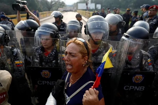 Venezuela's opposition supporters demand to cross the border line between Colombia and Venezuela at Simon Bolivar bridge as Venezuela's security forces stand in the border line blocking their way in the outskirts of Cucuta, Colombia, February 23, 2019. (Photo by Edgard Garrido/Reuters)