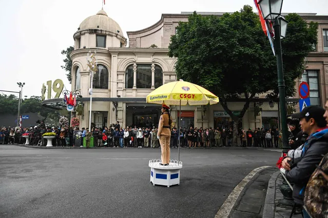 A Vietnamese policewoman stands guard as people gather around a street in Hanoi on February 26, 2019, ahead the second US-North Korea summit. (Photo by Manan Vatsyayana/AFP Photo)