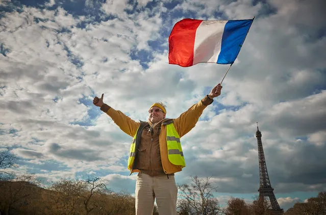A Gilet Jaune or Yellow Vest waves the French Tricolor flag during a demonstration near the Eiffel Tower as part of the National General Strike, organised by five French Unions in a demand for tax reforms and a rise in wages on March 19, 2019 in Paris, France. After four months of Gilets Jaunes or ‘yellow vests’ protests the strike, led by the CGT, FO, and Solidaires Unions as well as the student UNEF and UNL groups have joined the yellow vests in a general and national strike in a bid to not be sidelined in decisions of social and fiscal matters at the end of President Macrons great national debate last week. (Photo by Kiran Ridley/Getty Images)