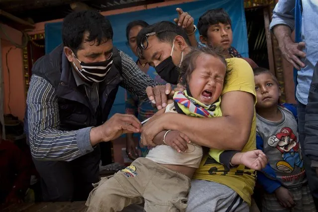 A Nepalese infant is given a vaccination in Lapsiphedi, near Kathmandu, Nepal, Monday, May 4, 2015. A campaign's underway in Nepal to immunize half a million children against measles and rubella in the wake of the earthquake. (Photo by Bernat Amangue/AP Photo)