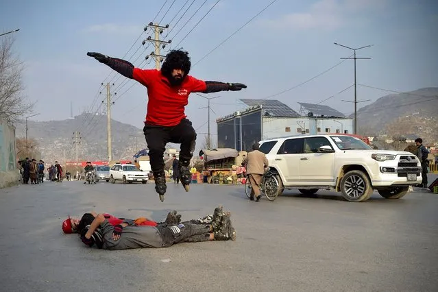 Youths perform artistic roller skating during a car racing competition in Kabul on January 26, 2024. (Photo by Ahmad Sahel Arman/AFP Photo)