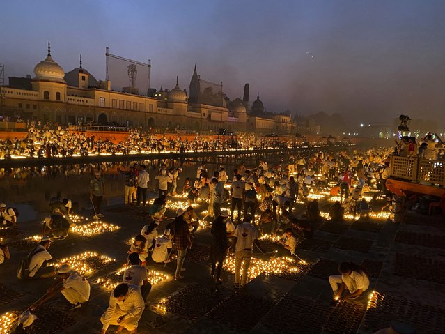 People light lamps on the banks of the river Saryu in Ayodhya, India, Wednesday, November 3, 2021. (Photo by Rajesh Kumar Singh/AP Photo)
