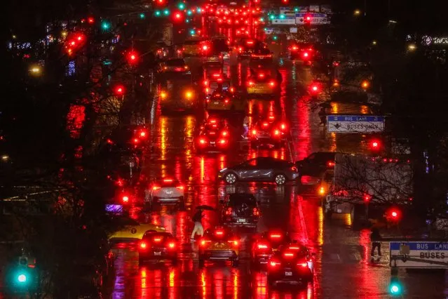 Pedestrians and cars move along First Avenue in the Manhattan borough of New York, in the pouring rain, on February 27, 2024. (Photo by Charly Triballeau/AFP Photo)