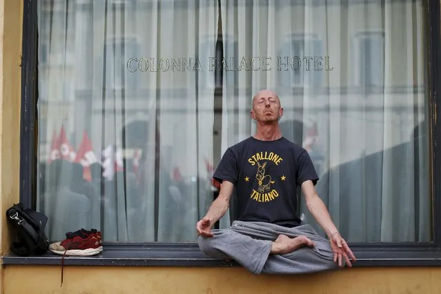 A protester wearing a t-shirt reading “Italian stallion” meditates as he sits cross-legged and barefooted on a window sill as other demonstrators are reflected in the window during a protest against the government's education reform, in Rome, Italy, May 5, 2015. (Photo by Alessandro Bianchi/Reuters)