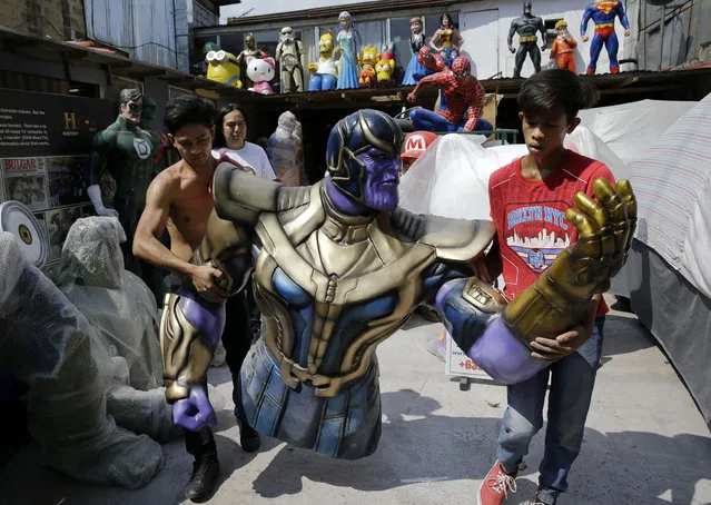 Workers carry a life-sized figure of Thanos, a character in the popular movie Avengers, as they prepare to display it outside their shop in Manila, Philippines on Friday, April 26, 2019. The shop specializes in making statues of superheroes and movie figures. (Photo by Aaron Favila/AP Photo)