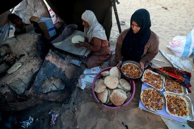 Displaced Palestinians prepare bread for an iftar meal, the breaking of fast, on the first day of the Muslim holy fasting month of Ramadan, inside a tent in Rafah in the southern Gaza Strip on March 11, 2024, amid ongoing battles between Israel and the militant group Hamas. (Photo by Mohammed Abed/AFP Photo)