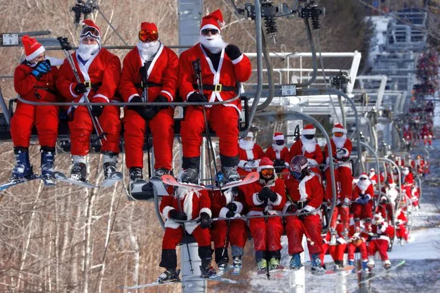 Skiers dressed as Santa Claus ride the lifts to participate in the charity Santa Sunday at Sunday River ski resort in Bethel, Maine, U.S., December 5, 2021. (Photo by Brian Snyder/Reuters)