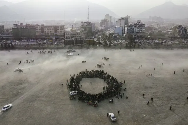 An aerial view of Chaman-e-Huzori park downtown Kabul Afghanistan, as people make a circle to watch wrestling matches , Friday, December 3 , 2021. (Photo by Petros Giannakouris/AP Photo)