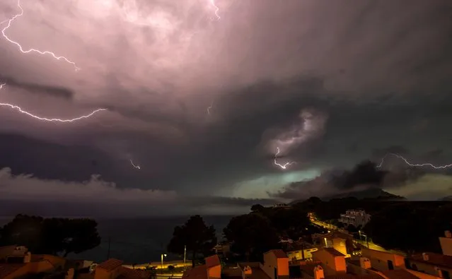 Lightning strike in the dark clouds over the Spanish Balearic island of Mallorca during a heavy thunder storm, near Andratx, Spain, 11 June 2018. (Photo by Cati Cladera/EPA/EFE)