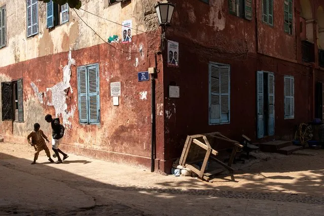 Boys play football next to a colonial era building in Goree island on March 29, 2024. (Photo by John Wessels/AFP Photo)