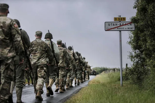 World War II enthusiasts and members of the US Army 4th Infantry Division march toward Utah Beach near Saint-Marie-du-Mont, Normandy, France, Tuesday, June 4, 2019. France is preparing to mark the 75th anniversary of the D-Day invasion which took place on June 6, 1944. (Photo by Rafael Yaghobzadeh/AP Photo)