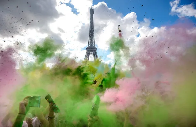 People covered in colourful chalk powder dance at the finish line after taking part in the Parisian edition of the “Color Run” in Paris, France, 17 April 2016. During the short foot race from the Hotel de Ville town hall to Trocadero across from the Eiffel Tower, runners are doused with colourful chalk. The initiative takes place in many cities around the world. (Photo by Christophe Petit Tesson/EPA)