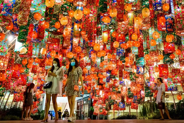 People walk under festive decorations for the upcoming Lunar New Year outside a shopping mall in Bangkok on February 3, 2021. (Photo by Mladen Antonov/AFP Photo)