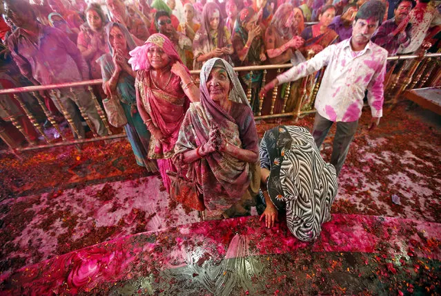 Devotees smeared with colours pray inside a temple during Holi, the Festival of Colours, celebrations in Ahmedabad, March 13, 2017. (Photo by Amit Dave/Reuters)