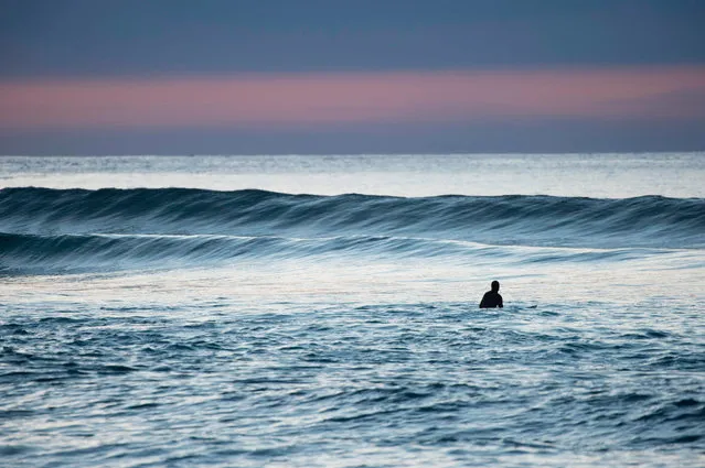 A surfer waits for a wave in Unstad along the northern Atlantic Ocean on March 12, 2017, where the water temperatures is at five degrees centigrade and the air temperature is at minus two degrees centigrade. (Photo by Olivier Morin/AFP Photo)