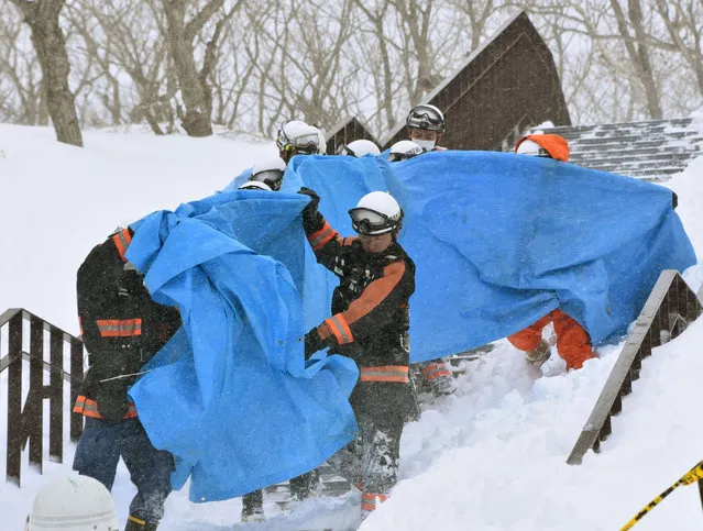 Rescuers carry the people who got injured in an avalanche at a ski resort in Nasu, Tochigi prefecture, Monday,  March 27, 2017. Authorities said six Japanese high school students have been found unconscious after they were caught in the avalanche Monday morning. (Photo by Kyodo News via AP Photo)