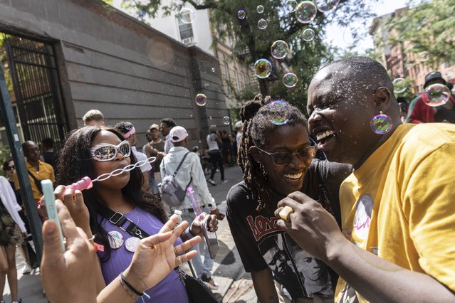 Maya Smith, left, blows bubbles during the Queer Juneteenth Block Party, sponsored by The Center, Sunday, June 18, 2023, in New York. (Photo by Jeenah Moon/AP Photo)