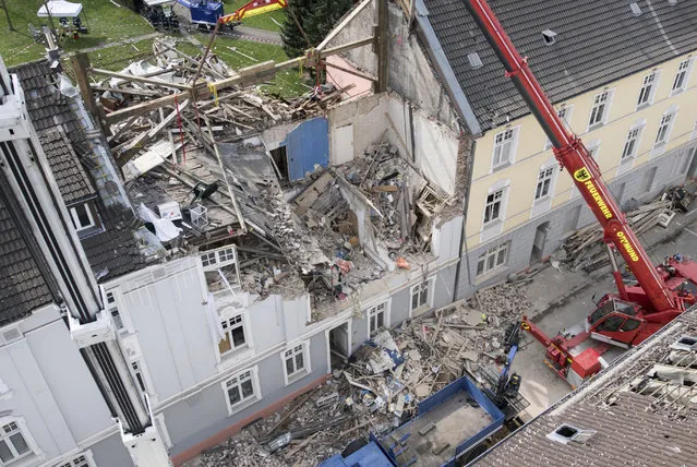 Cranes stand in front of an apartment building which was destroyed in an explosion on the previous day in Dortmund, Germany, Saturday, April 1, 2017. One person died in the explosion in the building. Rescue forces found the body of a female resident on Saturday morning. (Photo by Bernd Thissen/DPA via AP Photo)
