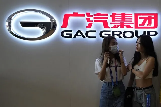 Two women stand near the logo for the Guangzhou Automobile Group Co. Ltd during an auto show in Beijing on Sunday, September 27, 2020. Carmaker Stellantis moves to consolidate its position in fast-growing China looked off to a rocky start after one of its JV partners said it hadn’t been consulted before an announcement of plans to take a controlling stake. Stellantis plans to lay out its strategy March 1, but has offered some hints in announcements this week. They include plans to increase the stake in Chinese partner GAC Stellantis from 50% to 75% under new rules allowing more foreign investment, and an announcement Friday that the other JV, with Dongfeng, had doubled sales in 2021. (Photo by Ng Han Guan/AP Photo)