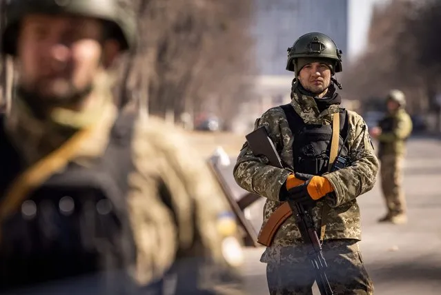 Ukrainian servicemen stand guard at a military check point in Kyiv on March 21, 2022. At least eight people are killed in the bombing of a shopping centre in northwest Kyiv today. The 10-storey building is completely destroyed in the blast. Russia claims the mall was used to store rocket systems. (Photo by Fadel Senna/AFP Photo)
