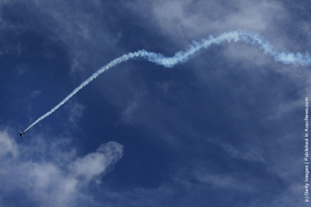A plane performs aerobatic moves  during the media preview ahead of the Singapore Airshow 2012