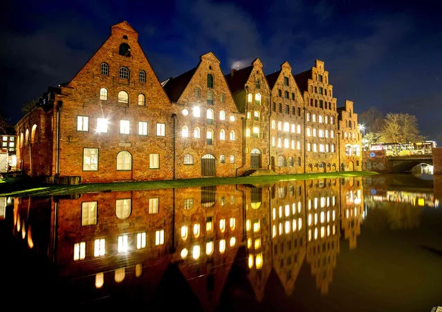 Lights burn in the medieval historic warehouses in Luebeck, northern Germany, late Thursday, January 6, 2022. (Photo by Michael Probst/AP Photo)