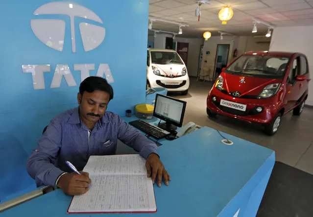 An employee writes on a register inside the Tata Motors car showroom in Ahmedabad, India, November 6, 2015. (Photo by Amit Dave/Reuters)
