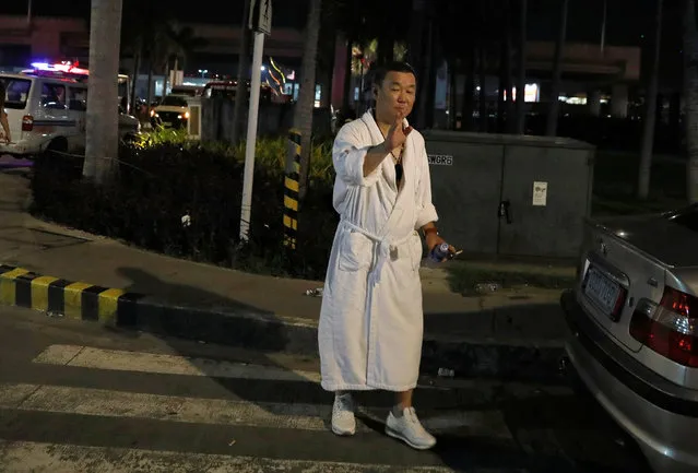 A tourist wearing a bathrobe gestures after he was evacuated from the Resorts World Manila after gunshots and explosions were heard in Pasay City, Metro Manila, Philippines June 2, 2017. (Photo by Erik De Castro/Reuters)