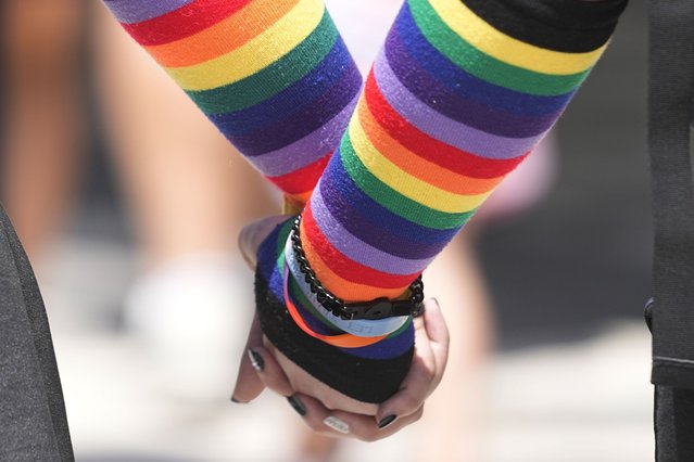 A couple hold hands at they leave the Pride Parade, Saturday, June 10, 2023, in Indianapolis. (Photo by Darron Cummings/AP Photo)