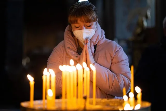 The congregation gathers and light candles during a Sunday service at the Saint's Peter and Paul Garrison Church on March 6, 2022 in Lviv, Ukraine. More than a million people have fled Ukraine following Russia's large-scale assault on the country, with hundreds of thousands of Ukrainians passing through Lviv on their way to Poland. (Photo by Dan Kitwood/Getty Images)
