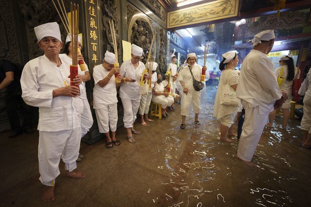 Ethnic Chinese Malaysian wait at a flooded temple on the eve of Nine Emperor Gods festival in Kuala Lumpur, Wednesday, October 11, 2024. (Photo by Vincent Thian/AP Photo)