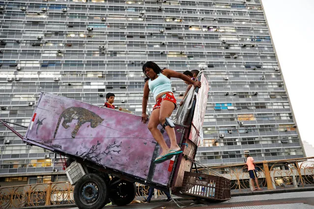 Fabiana da Silva, 38, a former crack user who now collects recyclable materials, jumps off her cart loaded with recyclables in Sao Paulo, Brazil on August 3, 2017. (Photo by Nacho Doce/Reuters)
