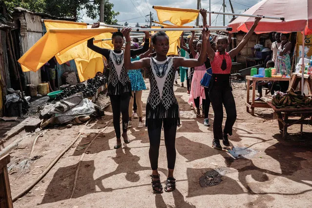 Members of “Project Elimu” perform as a part of their presentation in a street of Kibera slum in Nairobi, Kenya, on December 14, 2019. Project Elimu is Kenyan Non-Profit Organization founded by former professional Kenyan dancer Mike Wamaya to provide wide range of extracurricular activities to schools within informal settlements to empower children and teachers as over 400 children from 25 different schools participate. (Photo by Yasuyoshi Chiba/AFP Photo)