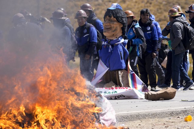 An effigy of former President Evo Morales burns on a road in Vila Vila, Bolivia, to block Morales supporters who are marching to the capital to protest the government of current President Luis Arce in an escalation of a political dispute between the two politicians, Tuesday, September 17, 2024. (Photo by Juan Karita/AP Photo)