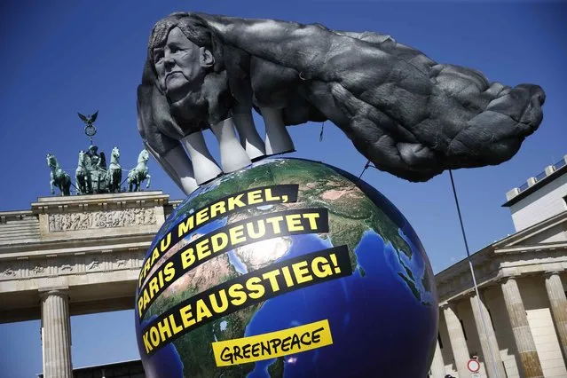 A model of a coal cloud on top of a globe set up by Greenpeace is seen during a protest in front of the Branderburg Gate in Berlin, Germany July 5, 2016. The text reads: “Mrs. Merkel, Paris means fossil fuel phaseout”. (Photo by Axel Schmidt/Reuters)