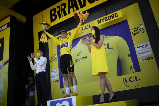 Belgium's Wout Van Aert, wearing the overall leader's yellow jersey, celebrates on the podium after the second stage of the Tour de France cycling race over 202.5 kilometers (125.8 miles) with start in Roskilde and finish in Nyborg, Denmark, Saturday, July 2, 2022. (Photo by Daniel Cole/AP Photo)